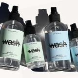 Five bottles of 'wash' antiseptic spray on a white background
