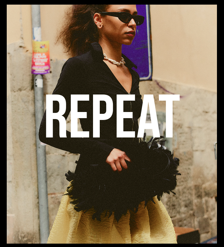 A woman wearing black sunglasses, a black long-sleeve top, and a black feathered clutch, paired with a textured yellow skirt. The word 'REPEAT' is printed in large white letters across the center of the image.