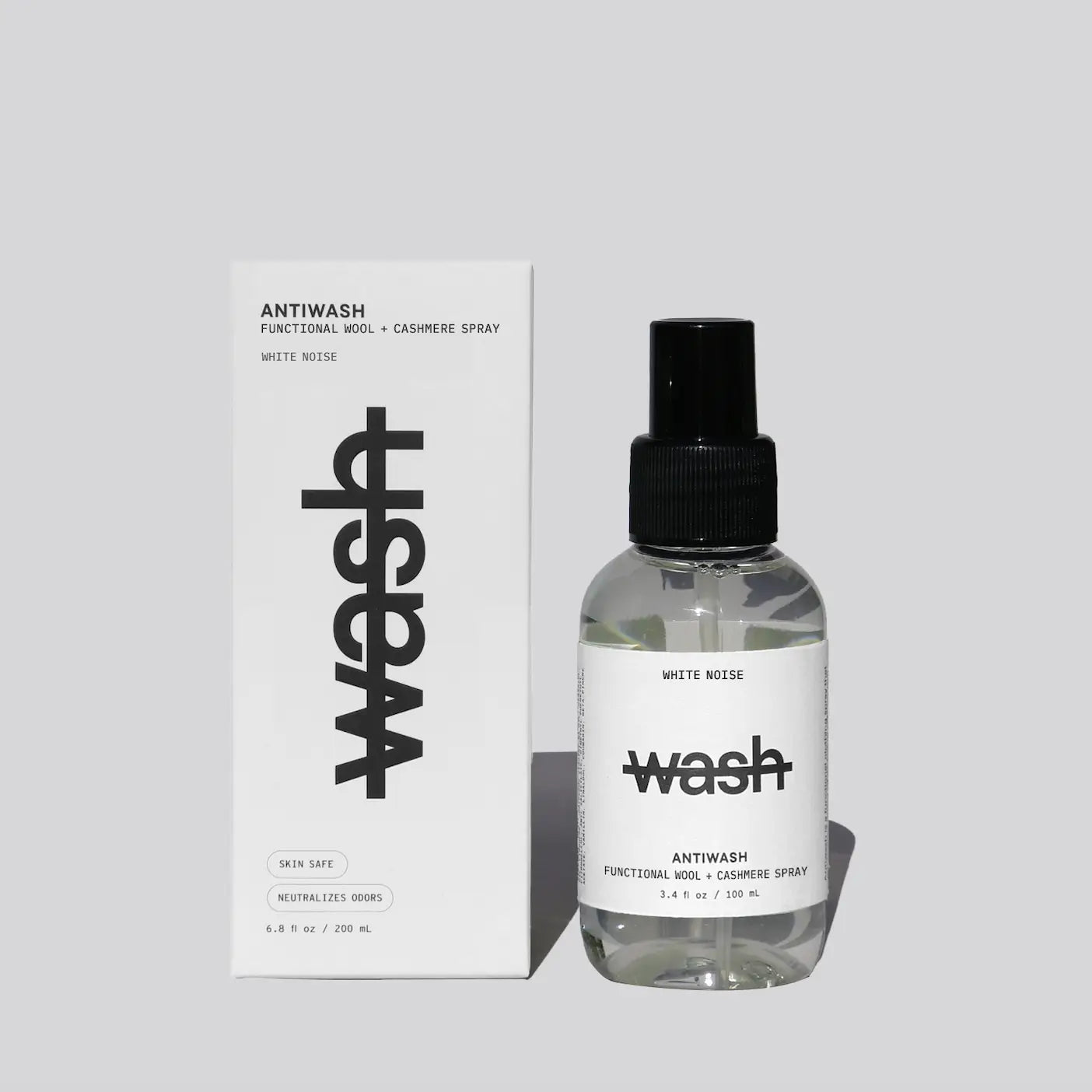 A clear 100ml spray bottle of wash antiwash functional soap and cashmere spray with a black pump, standing next to its white packaging box on a light gray background.